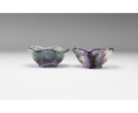 A pair of carved fluorite bowls with carinated rims, tapering bodies and small base ring; bodies with bands of colour ranging