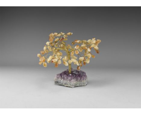 A medium size gemstone tree consisting of a brass trunk and branches tipped with polished citrines, mounted on a section of a