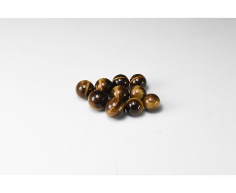 A group of ten tiger's eye spheres showing bands of black and brown silky lustre. 35 grams total, approx. 13mm (1/2"). From t