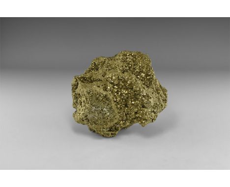 A massive boulder of pyrite crystals ranging in size from minute to larger formations, deeply striated and with a bright lust
