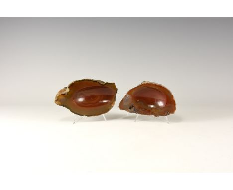 A group of two dark red and brown carved agate slabs with one surface dished to form a bowl, a fabric to the underside, colou