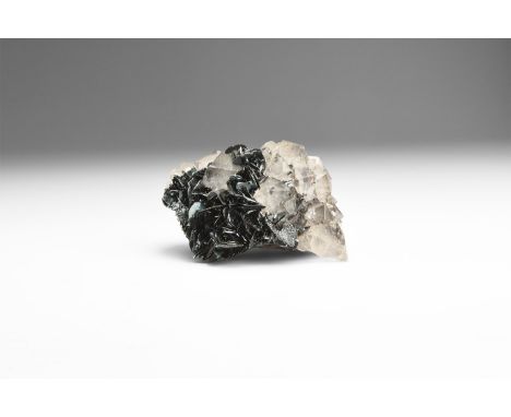 A fine specimen of double-terminated quartz crystals with specular hematite, in white card tray with label reading: 'QUARTZ A