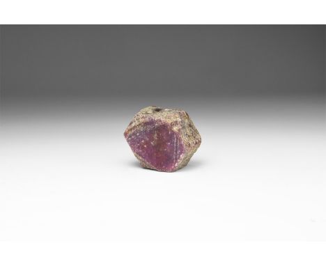 A single dark hexagonal red ruby crystal in a white card box with note reading: 'RUBY, Mysore, India'. 33 grams (165 carats),