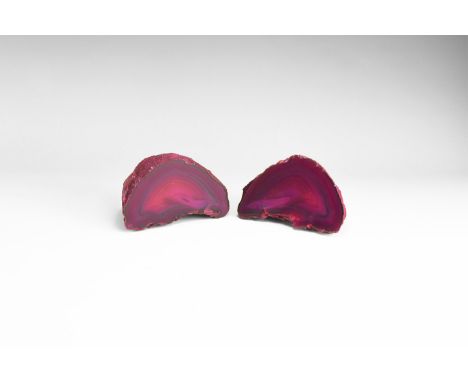 A pair of cut and polished banded agate geode of dark pink; colour enhanced. 902 grams total, 10.3cm (4"). From the historic 
