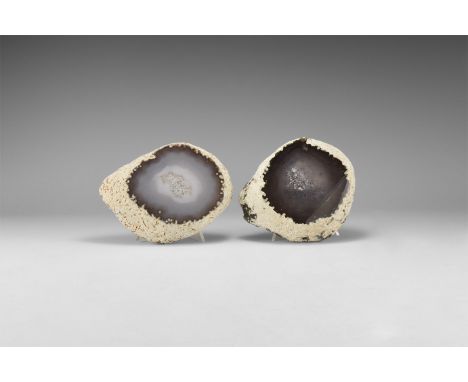 A pair of cut and polished agate geodes, with one enhydro dark blue example and one pale blue, both with crystalline quartz t