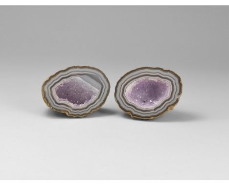 A pair of finely cut and polished mini geode of banded agate and pale purple crystals to the centre; in white card tray with 