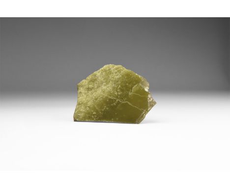 A cut and polished slice of apple-green jade, in old white card tray. 26 grams, 65mm (2 1/2"). From the historic ‘Victorian M