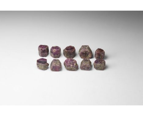 A group of ten dark purple hexagonal ruby crystals, from India. 123 grams total (615 carats), 17-19mm (3/4"). From the histor