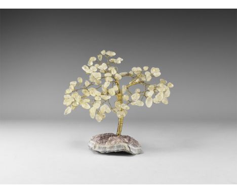A medium size gemstone tree consisting of a brass trunk and branches tipped with polished quartz, mounted on a section of ame