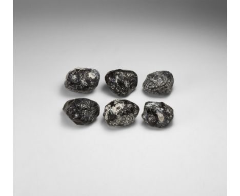 A group of six natural black obsidian (volcanic glass) specimens, each in white card box with label reading: 'APACHE TEAR, U.