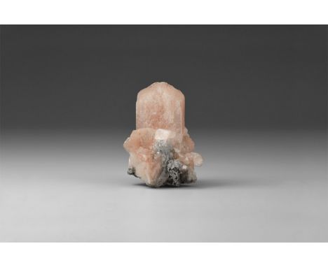 A fine specimen of pink stilbite, in white card box with label reading: 'STILBITE, Maharashtra, India'. 17 grams, 40mm (1 1/2