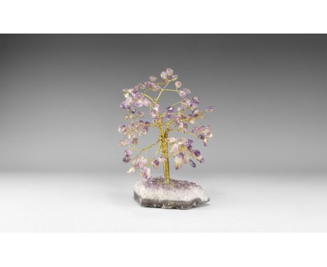A medium size gemstone tree consisting of a brass trunk and branches tipped with polished amethysts, mounted on a section of 