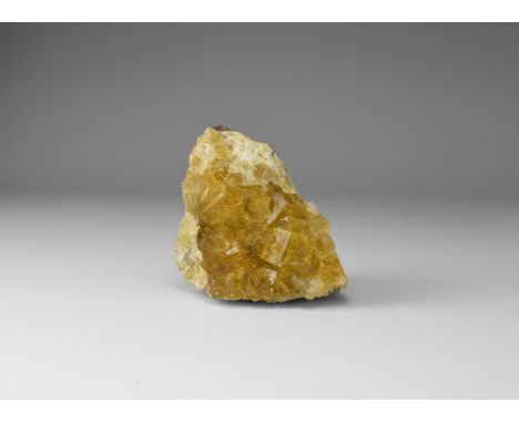A fine specimen of deep yellow fluorite crystals on a matrix, in white card tray with label reading: 'FLUORITE, Muscona mine,
