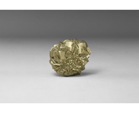 A group of large pyrite crystals circled around central area with smaller crystals, in white card tray with old label 'Pyrite
