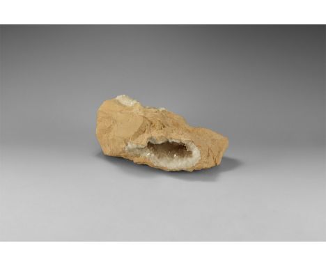 A vug (natural hollow) lined with transparent scalenohedral calcite crystals, open at three places to show a fine crystals. 2