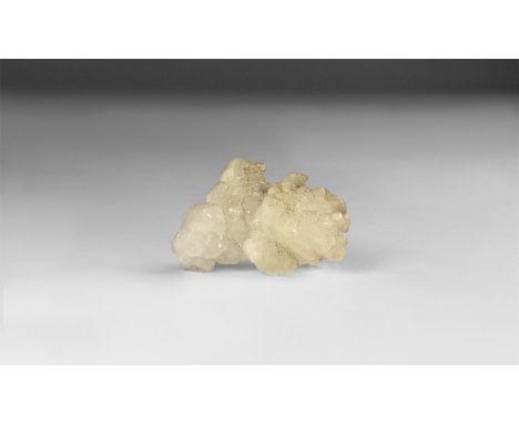 A fine specimen of white calcite crystals formation, in white card tray with label reading: 'WHITE CALCITE, Chihuahua, Mexico