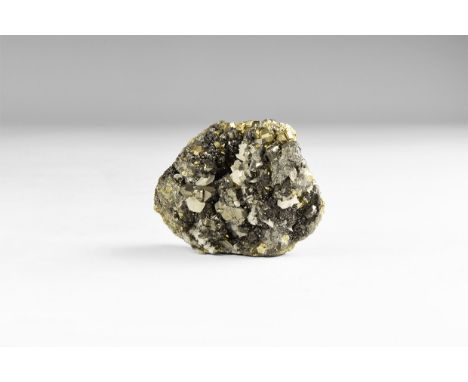 A fine specimen of bournonite with small cubes of pyrite and calcite crystals, in white card tray with label reading: 'BOURNO