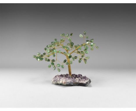 A medium size gemstone tree consisting of a brass trunk and branches tipped with polished green agates, mounted on a section 