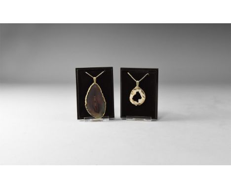 A group of two pendants of cut and polished agate slices, one large with smoky grey colour, one smaller with hollow centre fl