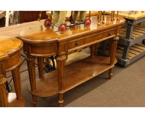 Walnut bow end single drawer console table raised on turned fluted legs joined by undershelf, 87cm by 157cm.