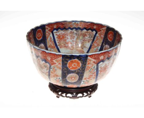 Japanese Meiji period Imari bowl with scalloped rim with fuku style mark on wood stand.