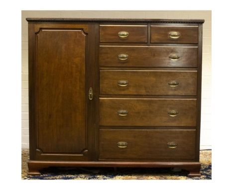 Edwardian mahogany compact wardrobe, dentil moulded cornice above panel door with two short and four long drawers, on ogee br