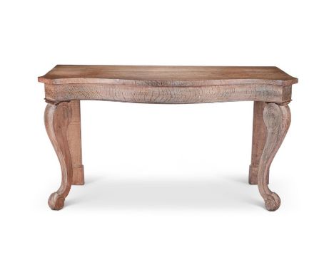 A William IV limed oak serpentine console table The shaped top above bold scroll carved cabriole legs and scroll feet, with p