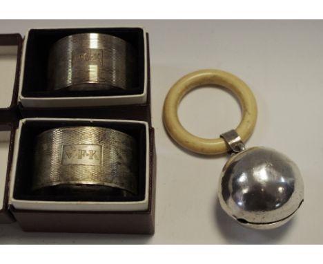 A silver baby's teething ball rattle, cream teething ring, Birmingham 1954;  a silver napkin ring, Mappin &amp; Webb, Birming