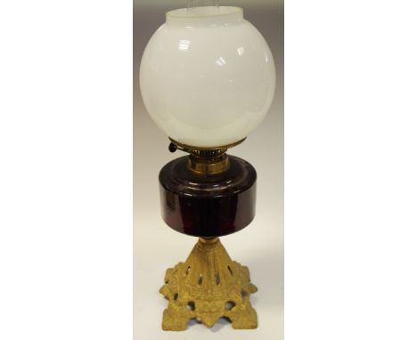A late Victorian/early 20th century oil lamp with cranberry glass reservoir, gilt metal base c.1900 