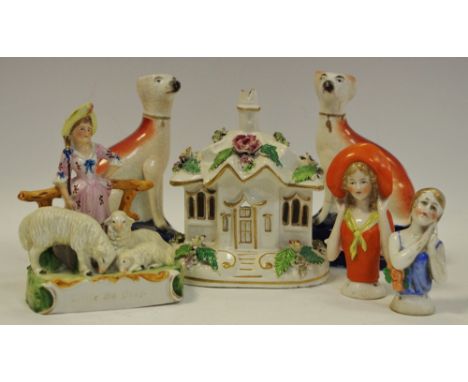 A pair of Victorian of Staffordshire seated greyhounds pen holders; a pastille burner in the form of a small cottage; two cer