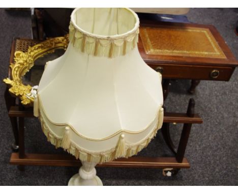 A substantial alabaster lamp base; reproduction tooled leather inlaid occasional table; rattan piano stool and ornate mirror 