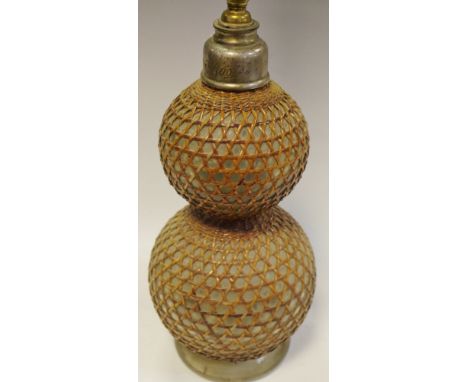 An early 20th century double gourd shaped glass soda syphon impressed Boots, Cash Chemists to neck, lattice work covered body