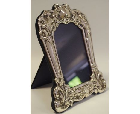 An Art Nouveau style silver easel photograph frame, embossed with flowers and sinuous whiplash lines, 20.5cm high, Birmingham