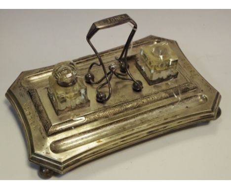 A Victorian silver plated standish, canted rectangular base, two clear glass inkwells, shaped ball and bar looping handle, fl