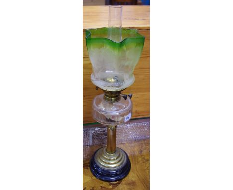 An early 20th century brass oil lantern, graduated green and opaque shaped Art Nouveau shade, clear reservoir, plinth base c.