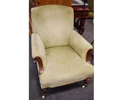 A Victorian library chair, padded back, scrolling arms, stuffed overseat, turned fore legs, ceramic casters.