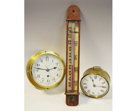 A brass porthole clock, enamel dial with stylised numericals, single winding hole; a brass desk clock, white enamel dial, bla