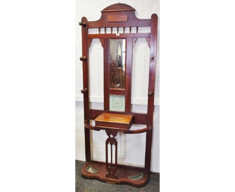 A late Victorian mahogany hall stand, shaped top rail, rectangular mirror flanked by coat pegs. glove box and stick stands to