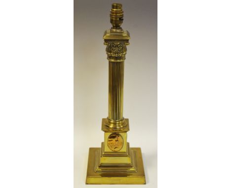 An early 20th century Corinthian column brass lamp base, inset with Art Nouveau plaques to stepped plinth base c.1900 