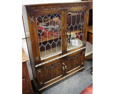 A Jaycee furniture oak side cabinet, rectangular top above a pair of glazed doors enclosing two shelves and a further pair of