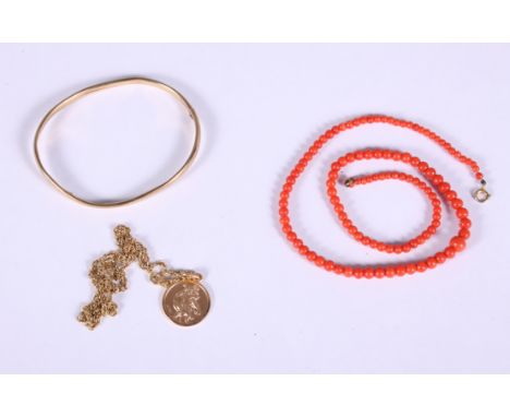 A 9ct gold St Christopher pendant on a 9ct gold chain, an unmarked yellow metal hinged bangle and a red coral necklace