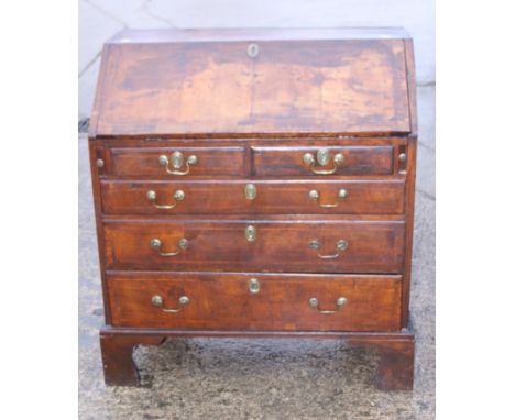 A late 18th/early 19th century inlaid walnut fall front bureau, fitted two short and three long drawers with swing brass hand