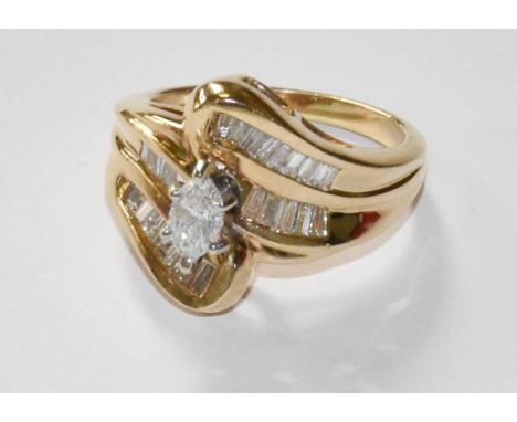 A 14 Carat Gold Diamond Ring, the central raised marquise cut diamond in a white claw setting, to baguette cut diamond set tw