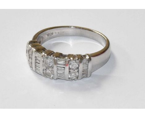 A Diamond Ring, three pairs of round brilliant cut diamonds spaced by tapered baguette cut diamonds, in white claw and channe