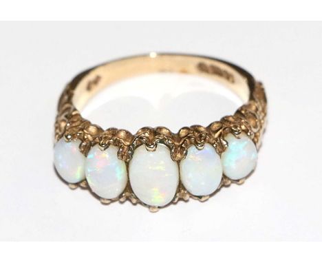 A 9 Carat Gold Opal Five Stone Ring, the graduated oval cabochon opals in yellow claw settings, finger size NGross weight 3.9