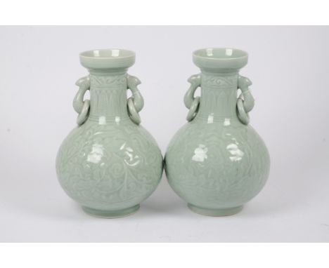 A pair of Chinese celadon glazed lamp bases, loop and ring handles, low relief foliate decoration, traces of character marks 