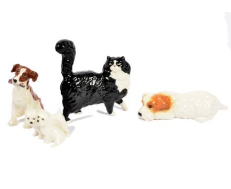 A collection of Beswick ceramic models of dogs, including Terrier Lying, no. 1061; 'Gnawing', no. 2947; and West Highland Whi