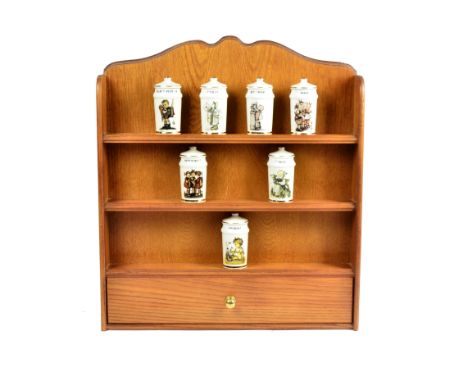 An M.J.Hummel ceramic spice jar set, comprising 24 individually named and decorated jars and covers, together with a wooden w