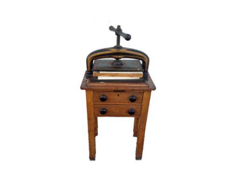 A vintage cast iron book press, black and gilt decoration, wooden stand with two drawers, 110 cm high including stand