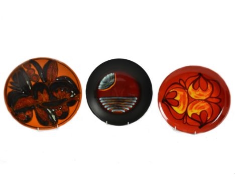 A collection of Poole Pottery chargers and plates, including a limited edition Millennium collection plate designed by Alan C
